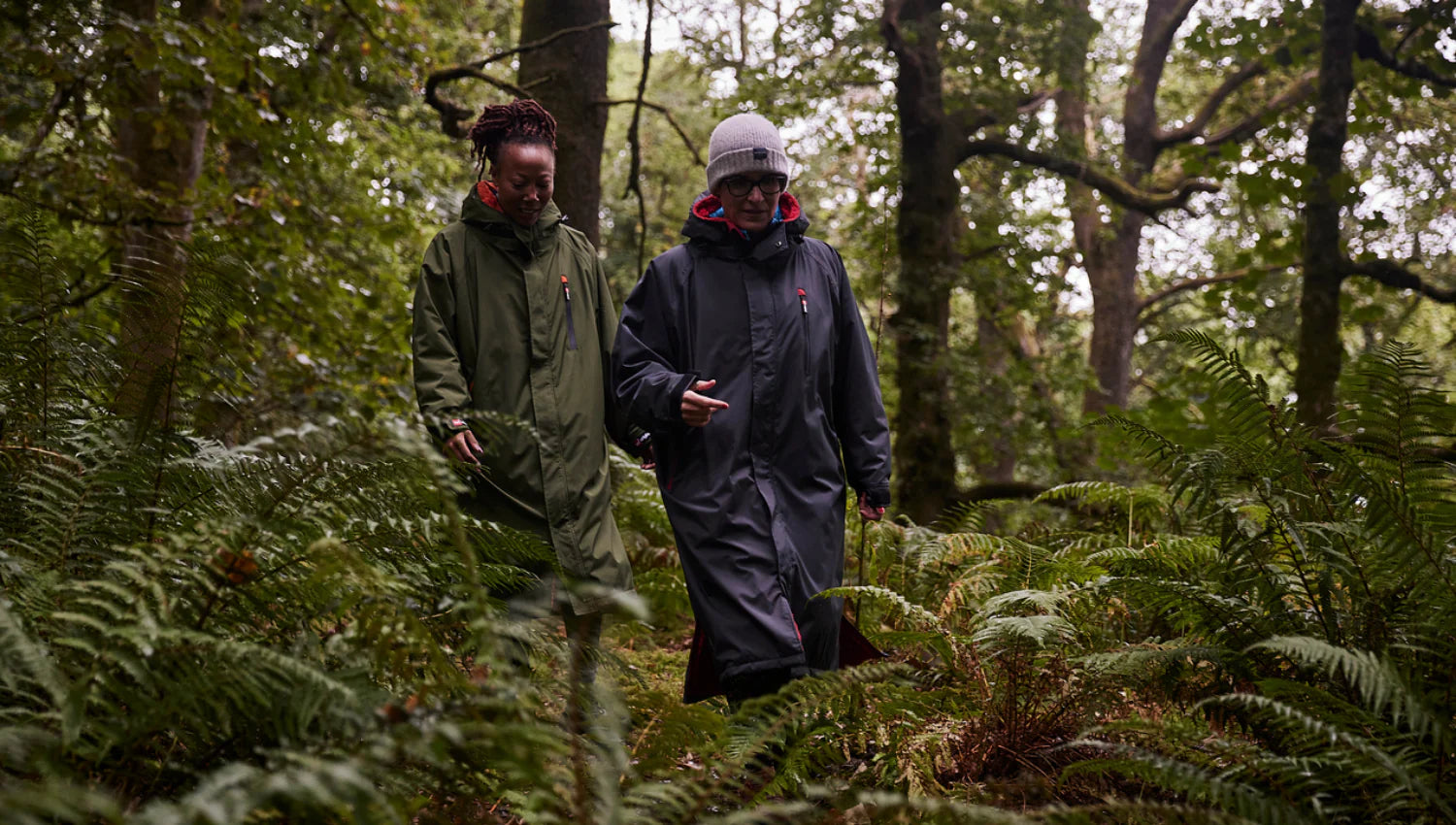 2 people wearing their Red Pro Change Robe whilst walking through the forest