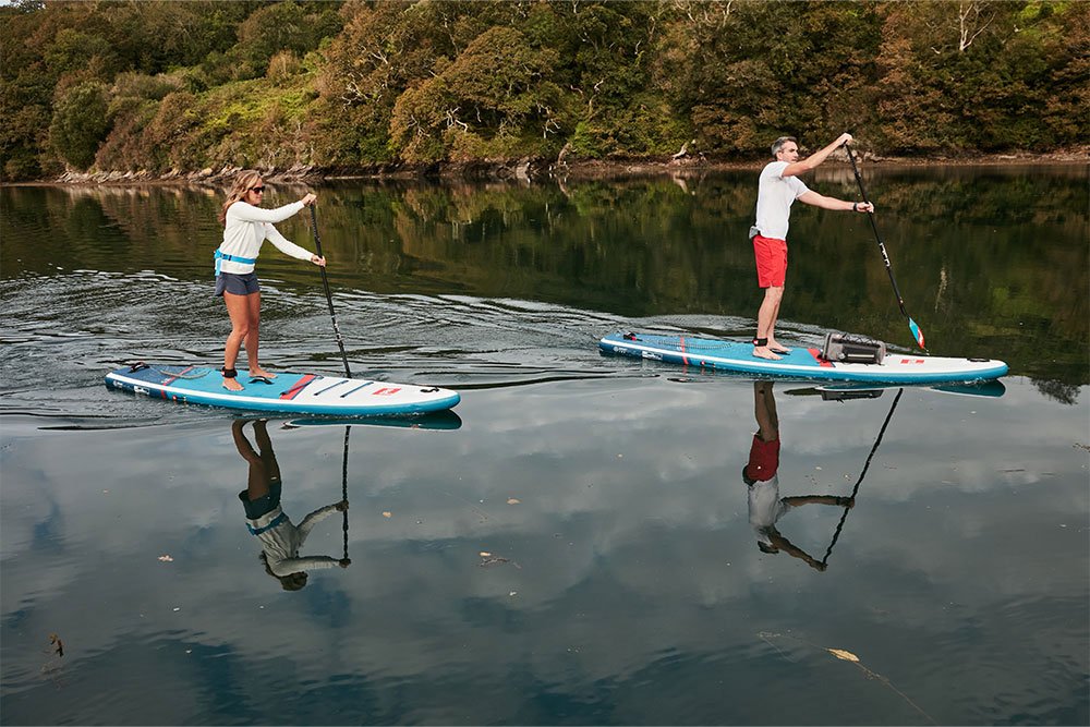 Man and woman on a lake paddling Touring SUP Boards