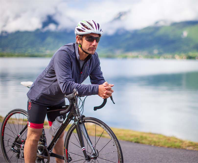 Man sat on bike wearing Red Original long sleeved performance top