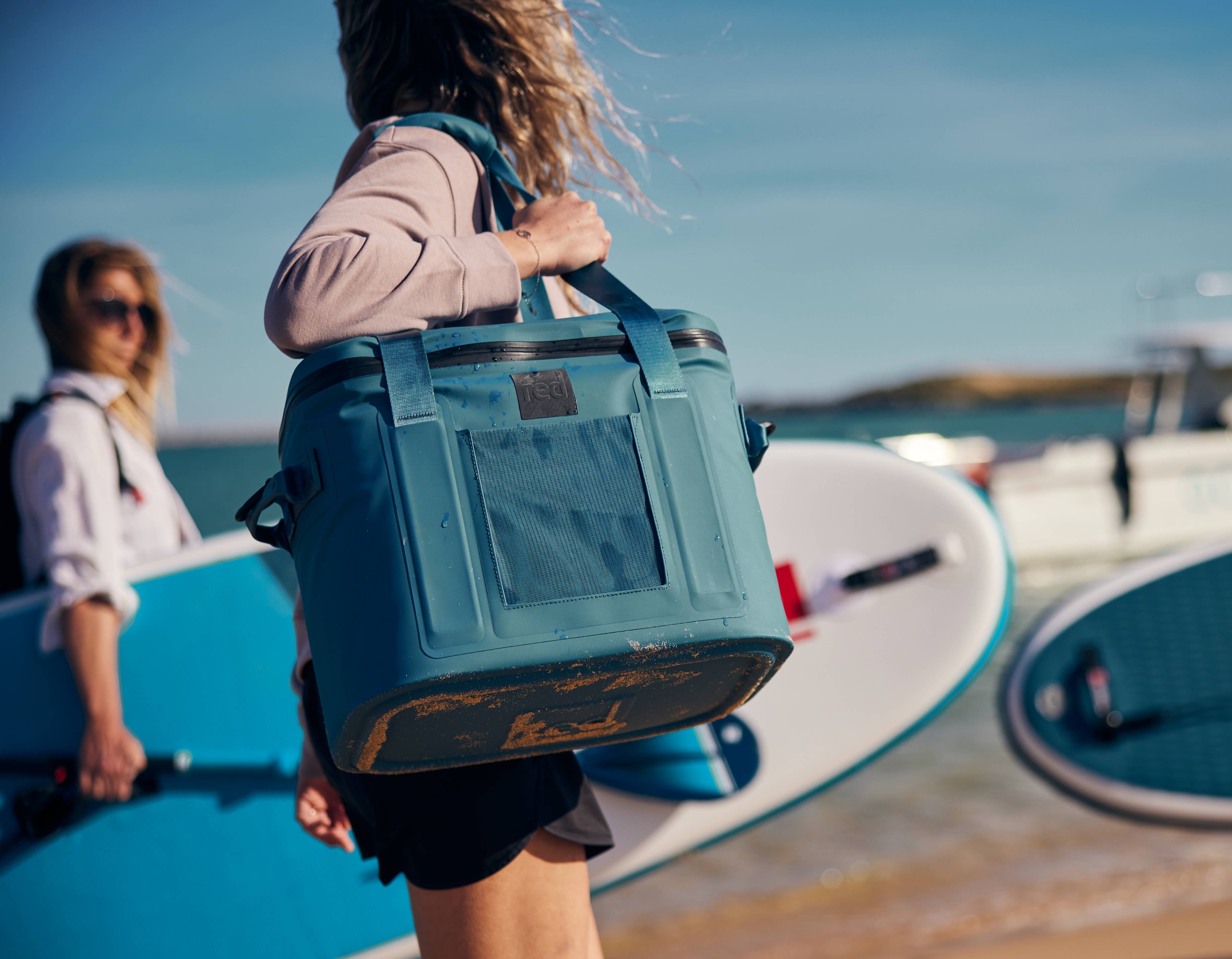 woman carrying waterproof cooler bag on the beach