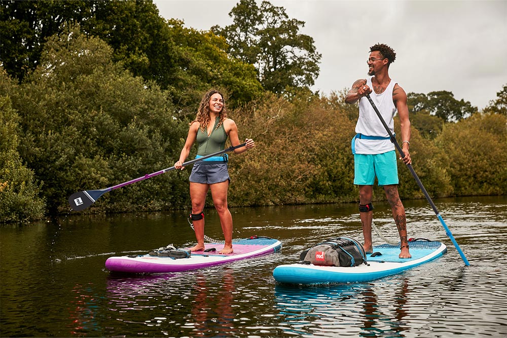 Man and woman paddling Red Original 10'6" SUP's