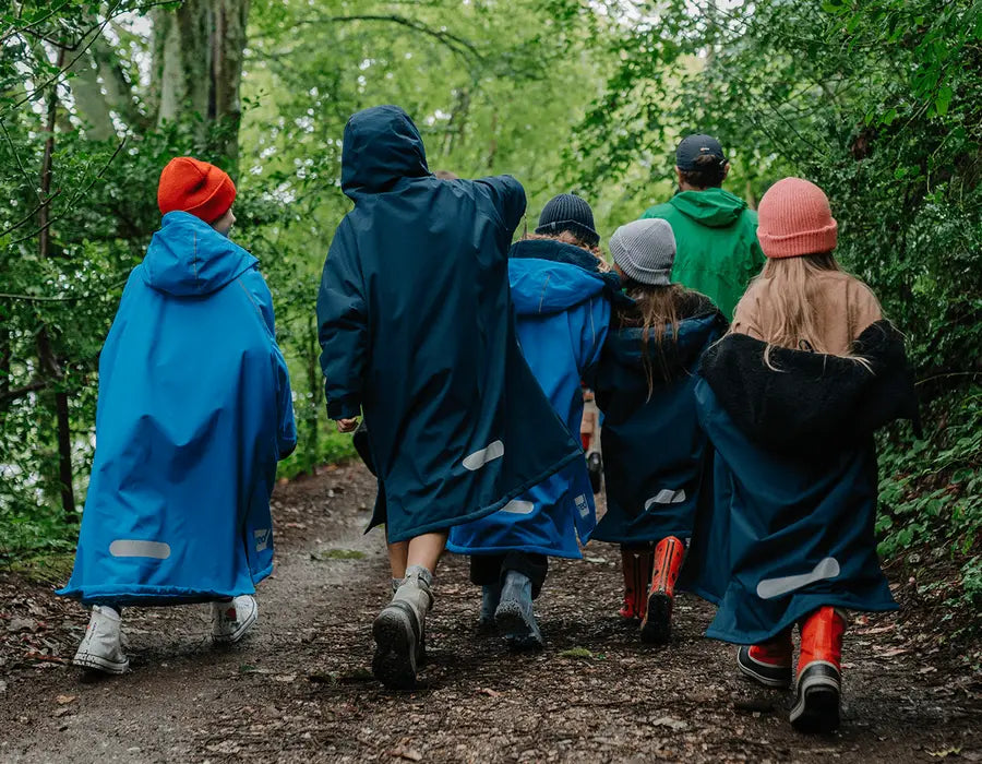 A group of children walking through the forest wearing their Red Pro Change Robes