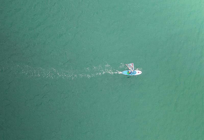 aerial shot of someone windsurfing