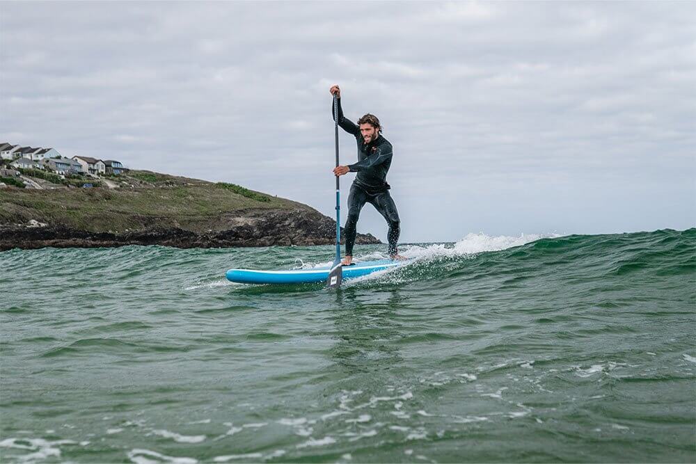 man paddling on Whip MSL inflatable paddle board in the surf