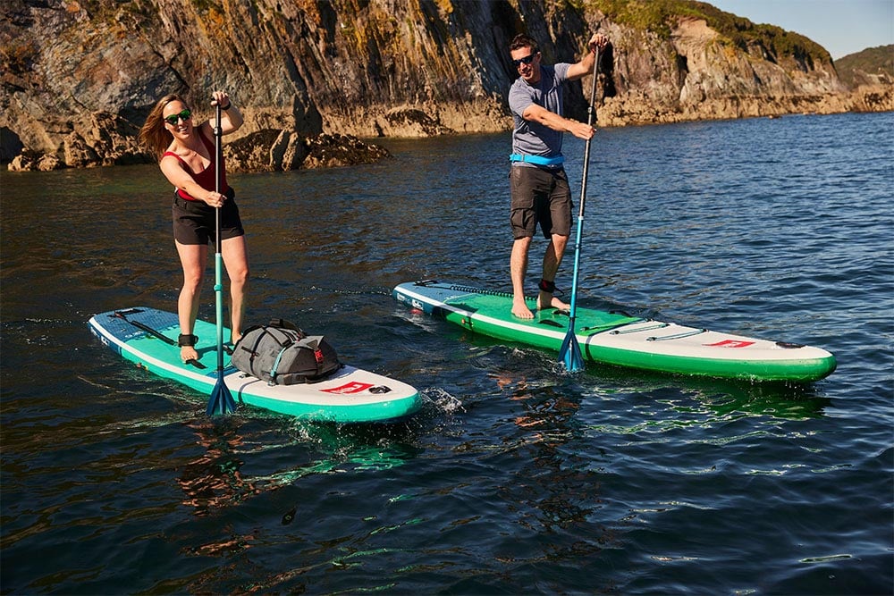 Two people paddling Red 12’0” Voyager MSL inflatable paddle board