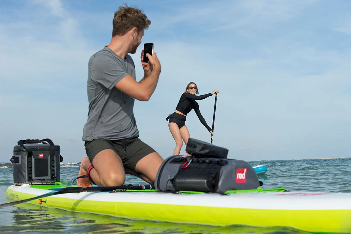 man and woman on paddleboard with deck bag 