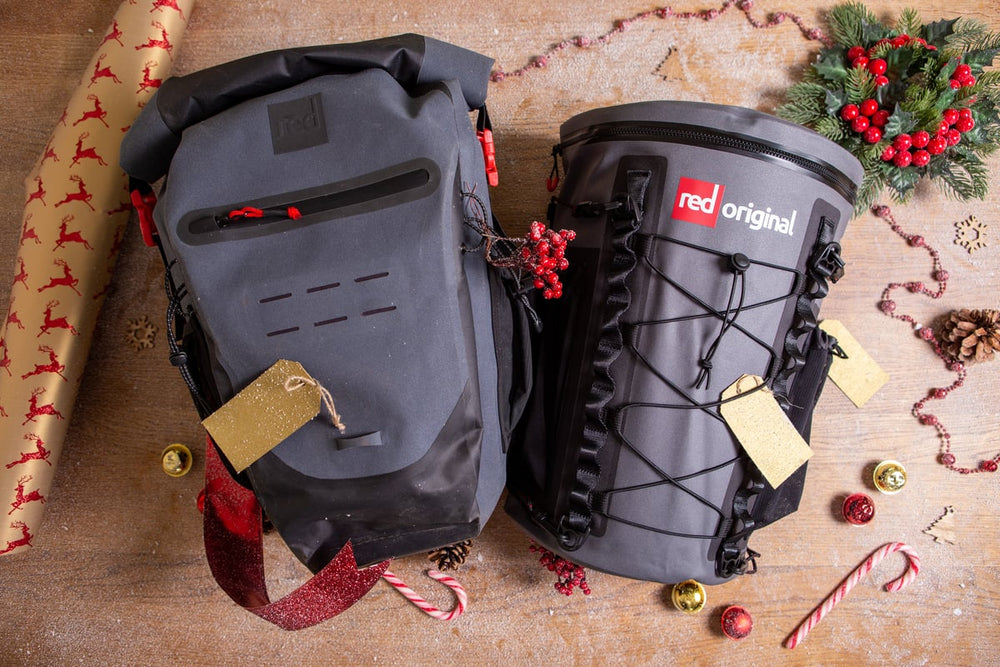 Two Red Original backpacks surrounded by Christmas accessories