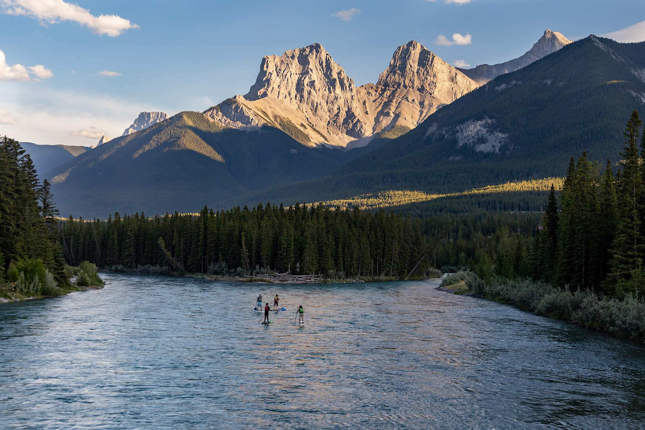 Group of people paddle boarding with mountains in the background, Canmore, Alberta, Canada.