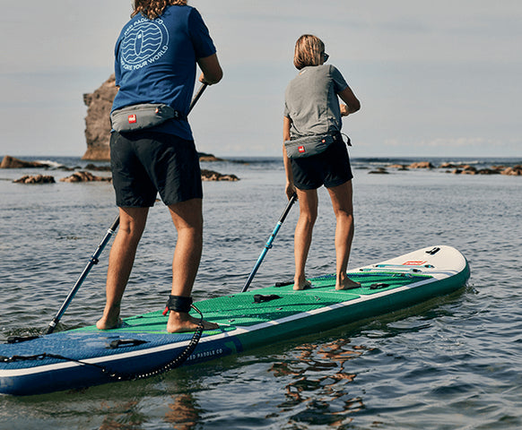 Two people paddle boarding in the sea