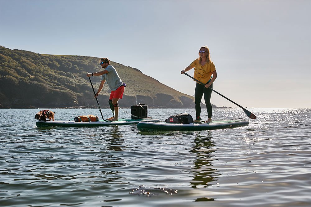 Man and and woman paddle boarding on lake