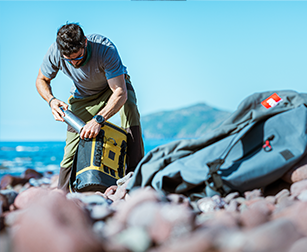 Man hiking using a mustard waterproof cool bag backpack